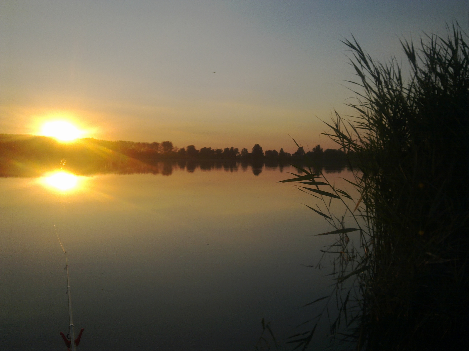 Lemenő nap a tófelett